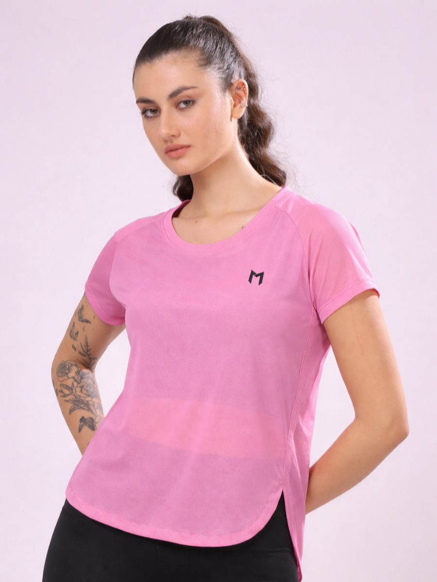 Woman wearing a pink athletic shirt with a logo on a light purple background